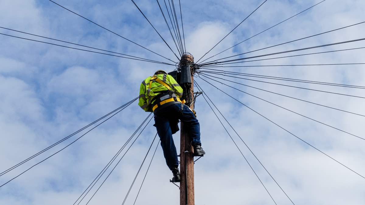 BT worker climbing pole to fix cables