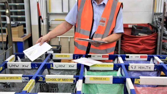 A Royal Mail worker sorting post in a delivery office