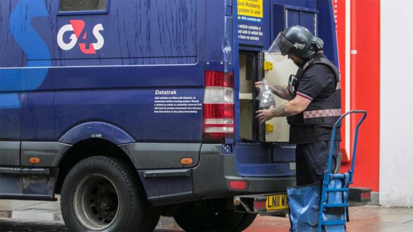 A G4S Cash worker making a delivery from a van