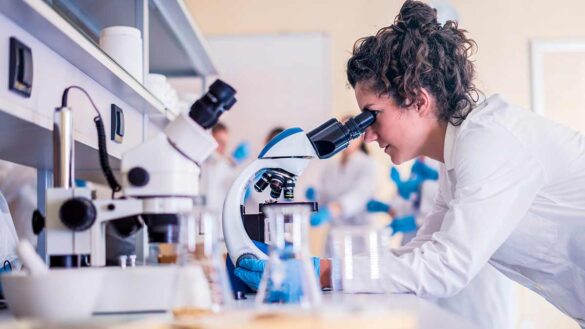 A female scientist using a microscope in a laboratory