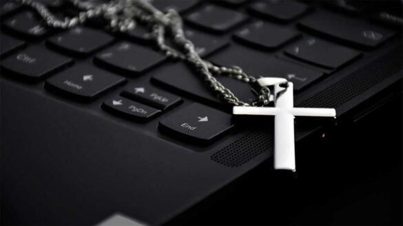 A cross necklace on a laptop