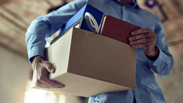 A man with a cardboard box full of possessions
