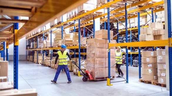 A warehouse worker pulling a pallet of boxes