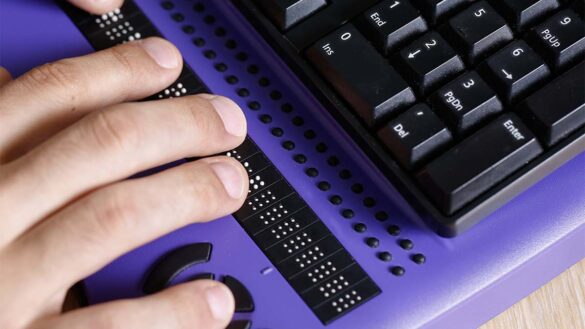 A blind worker using a braille keyboard
