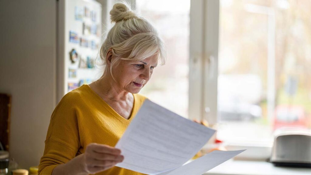 An older woman looking at a pension statement. Illustrating the gender pensions gap