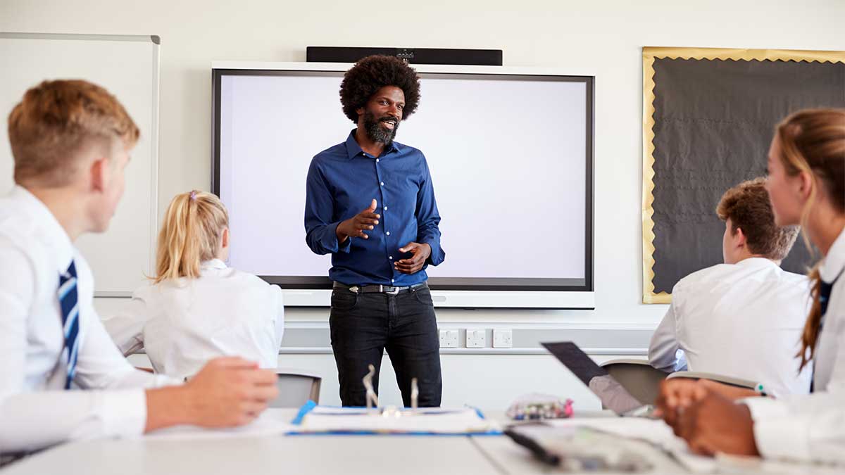 Experienced teachers. Male teacher talk to girl pupil. Stand next to misbehaving students..