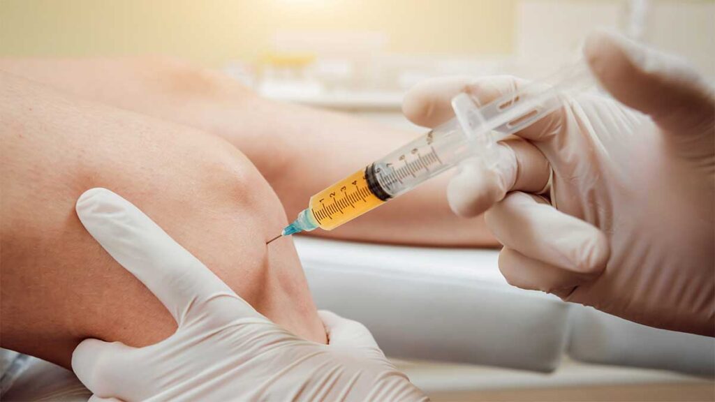 A physio administering a PRP injection into a knee