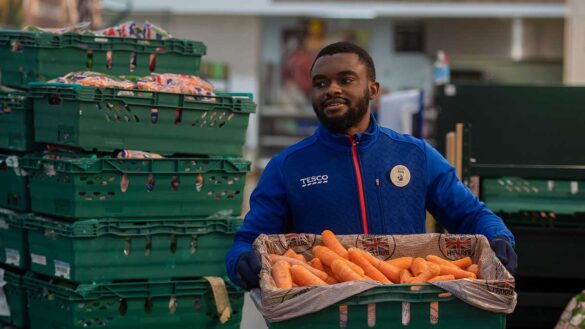 Tesco pay rise 2024. A tesco store worker with a crate of carrots