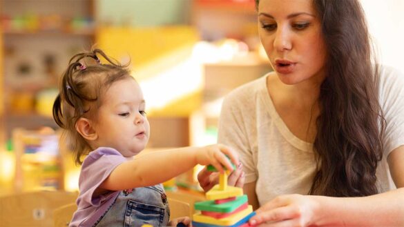 A woman playing with a toddler