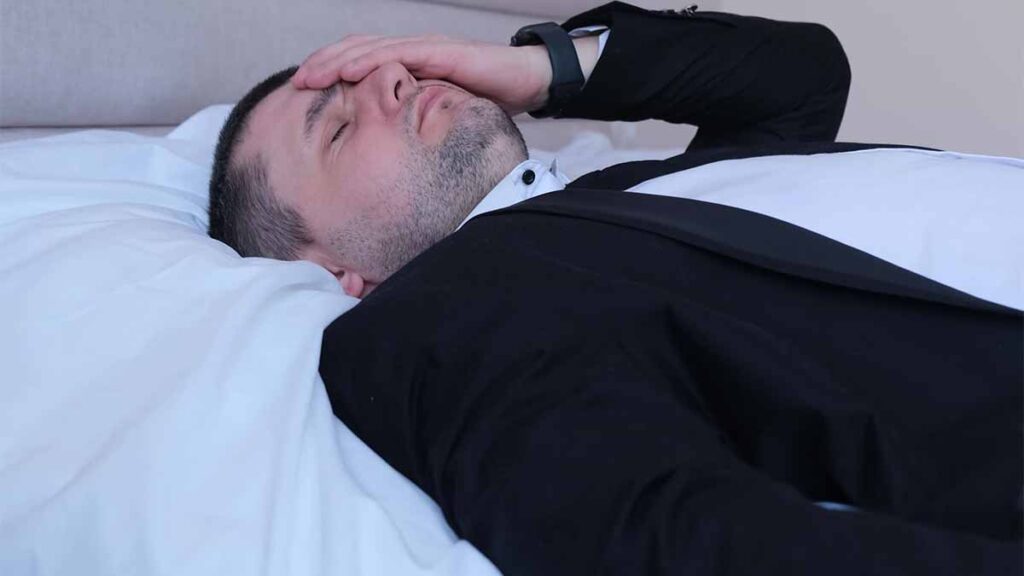 A man in bed with migraine
