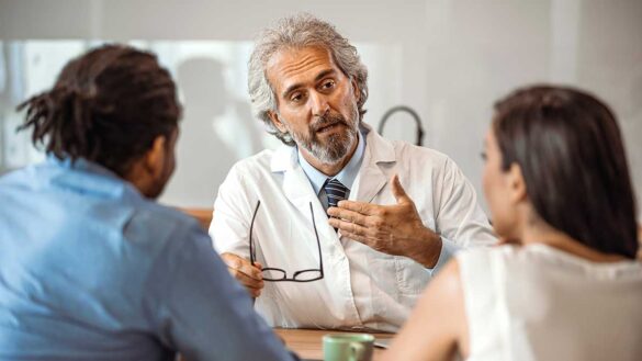 A doctor talks to a couple about fertility treatment.