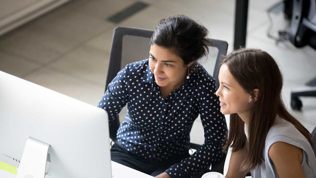 Two women looking at a computer screen in an office