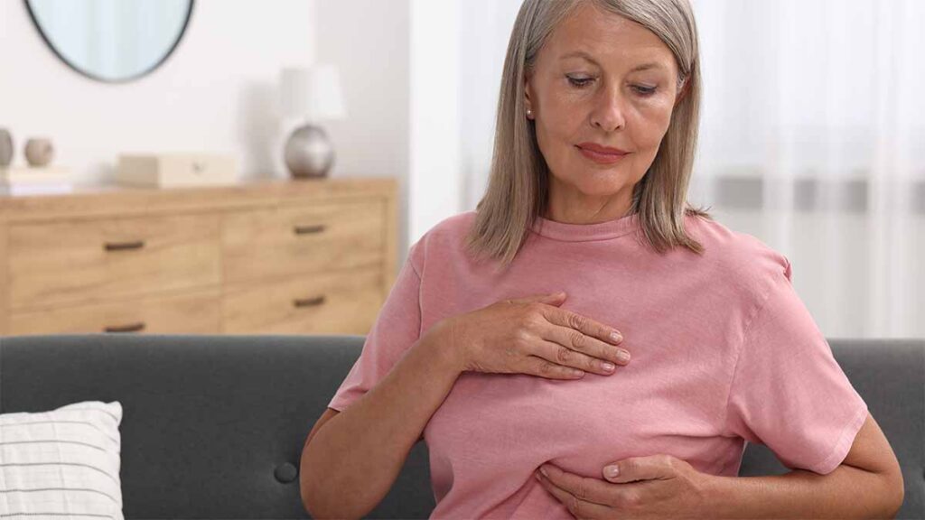 A woman checking for breast cancer