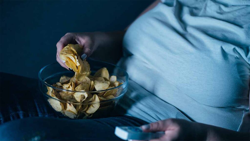 A depressed woman eating ultra-processed foods