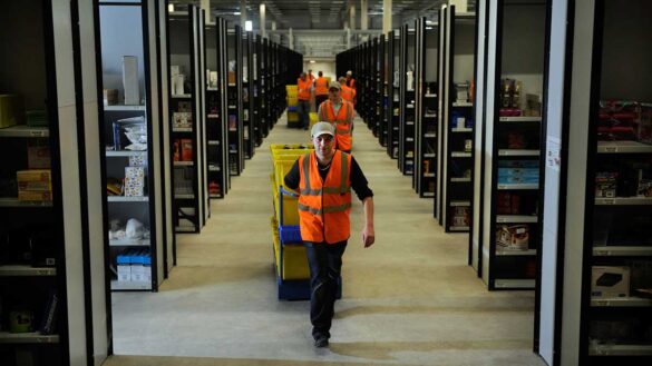 Amazon workers pulling trolleys in its Swansea warehouse
