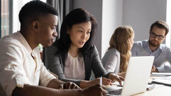 A group of workers looking at a laptop screen