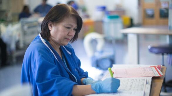 A nurse filling out paperwork in a hospital