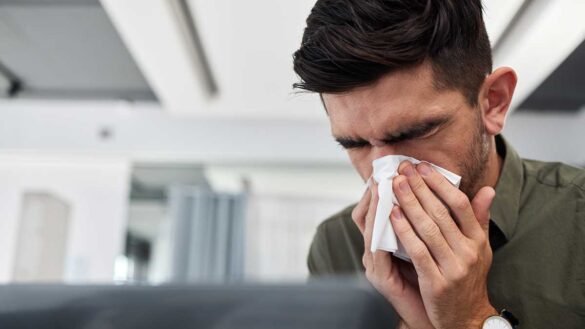A man blowing his nose at work