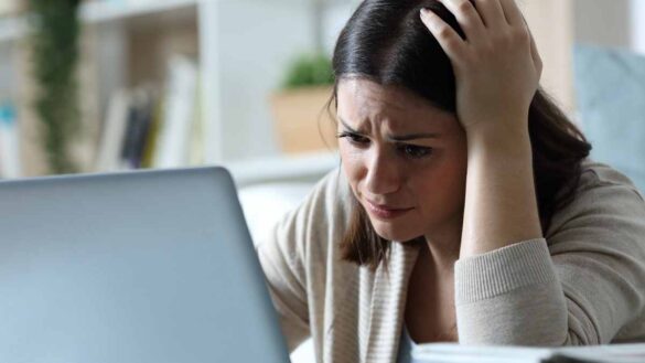 A woman looking frustrated while using a computer