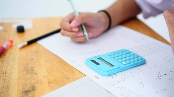 A student taking a maths exam with a calculator