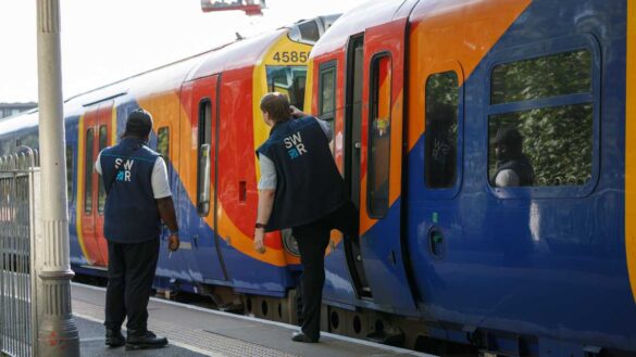 Two train crew members checking a platform before a train departs