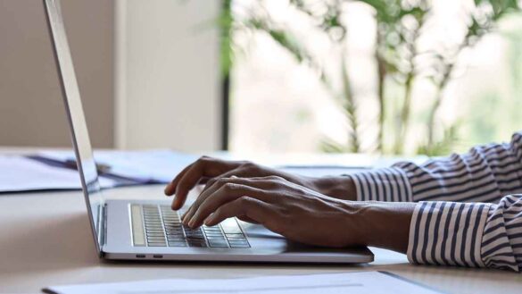 A woman typing on a laptop in an office