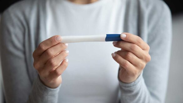 A woman holding a pregnancy test