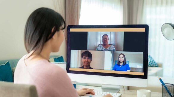 A woman with her colleagues on screen during a video meeting