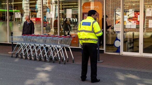 A security guard outside a supermarket