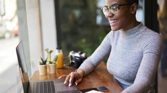 A smiling woman working on a laptop