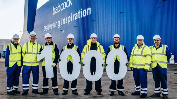 Employees at Babcock carrying large letters spelling out '1000'