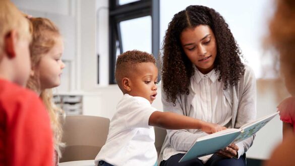 A young woman looking at a book with children