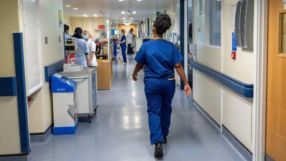 A health worker walking down a corridor in an NHS hospital