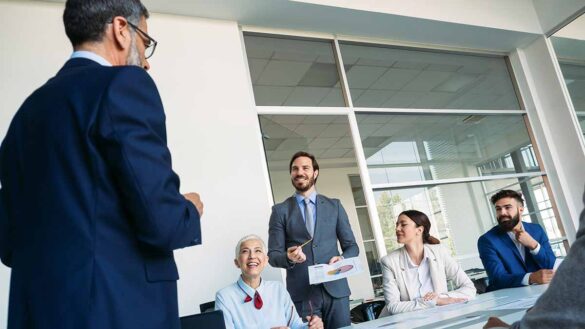 A man presenting to a diverse group of people in an office