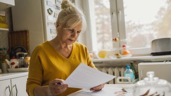 A woman looking at paperwork on her kitchen table