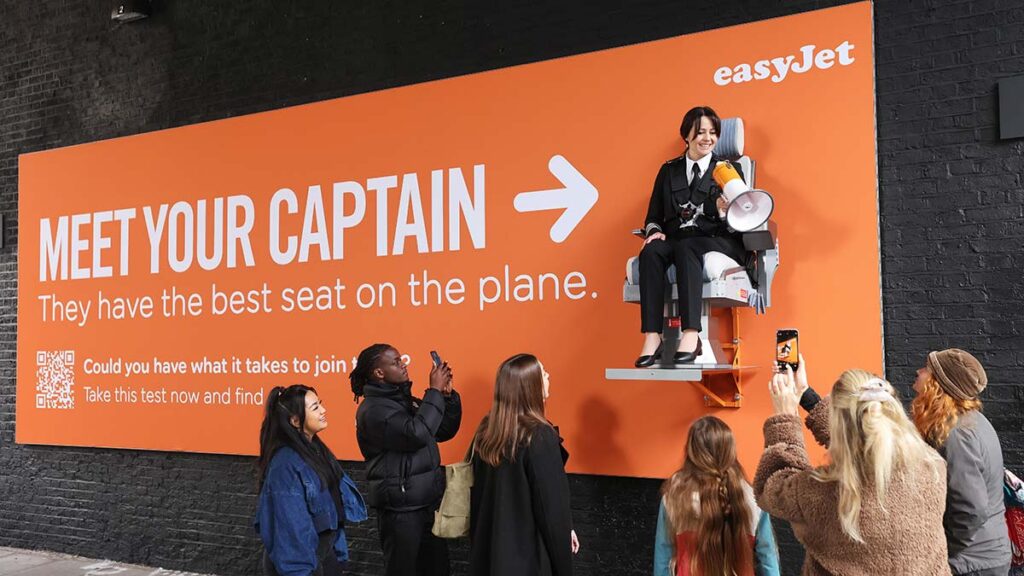 A real-life pilot was strapped to an easyJet billboard to answer questions