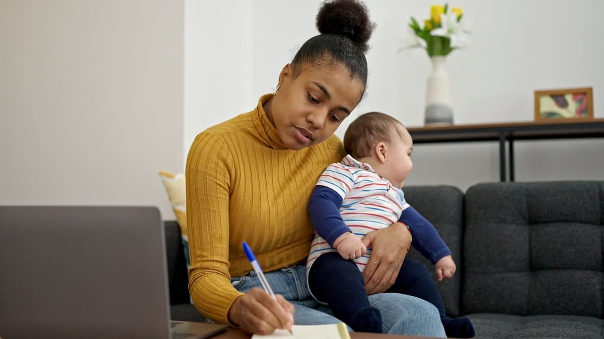 Woman working and holding baby