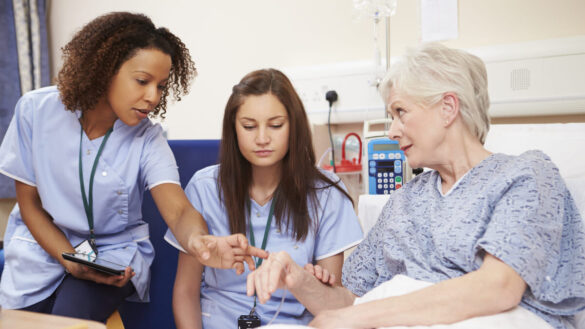 Nurses and woman in hospital bed