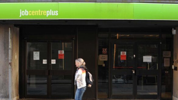 A woman walking past a JobcentrePlus branch