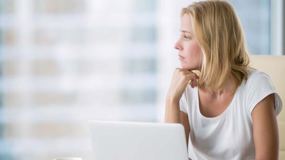 Slow thinking: Woman with a laptop stares out of the window