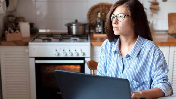 Lonely workers: image shows a woman working from home looking unhappy.