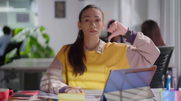 Gen Z shun middle management roles: Woman in her 20s at work with her thumbs down.