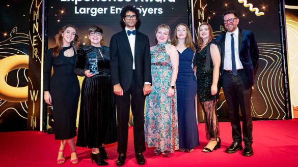 The Teleperformance team surround Richard Ayoade as they collect their Employee Experience trophy at the Personnel Today Awards 2024