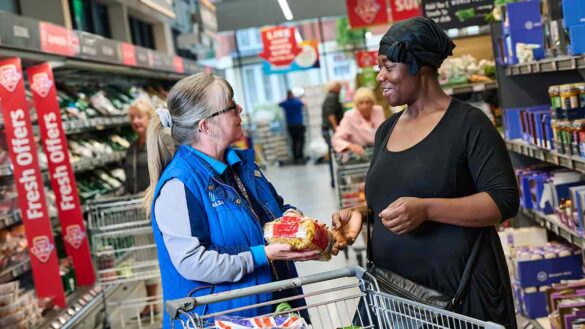 Aldi store assistants pay: a store assistant speaking with an Aldi customer.