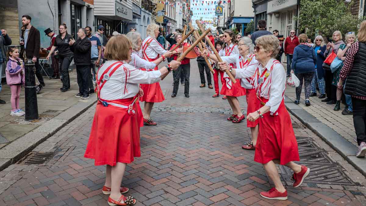 bank holiday pay. Photo shows women dancing at the Rochester Sweeps Festival