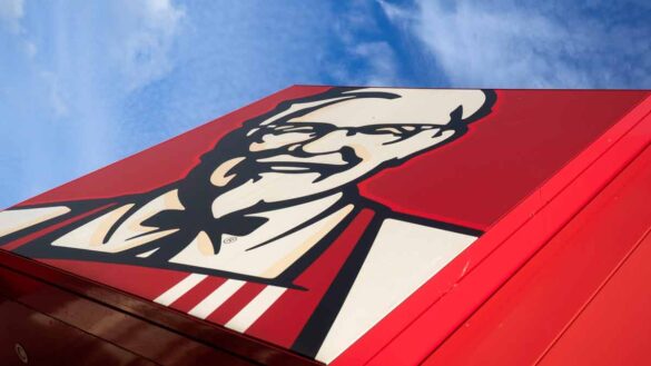 KFC creates jobs. Image shows KFC's Colonel Sanders sign against a blue sky.