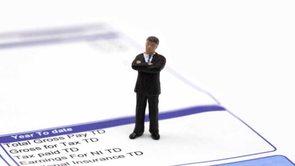 Salary sacrifice tax exemptions. Image shows a miniature model man standing on a pay slip.