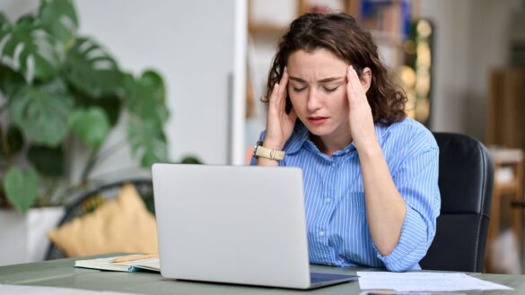 young woman looking a bit stressed at laptop