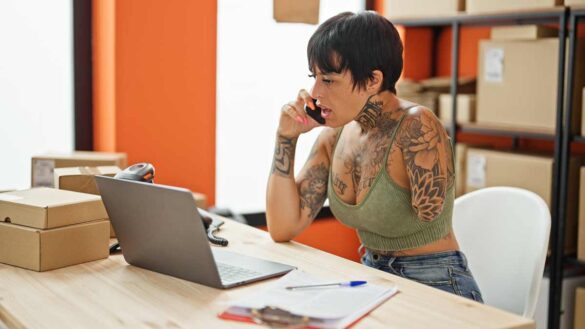 Disability harassment, bullying, discrimination. Photo shows woman with an amputation on a phone and laptop.