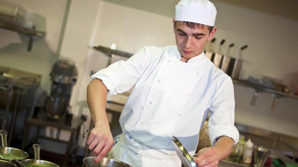 Young people poor mental health. Photo shows stessed chef in a kitchen.